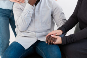 Women holding the hand of an African American patient during cocaine rehab in Itasca, IL at Fox Valley Behavioral Health.